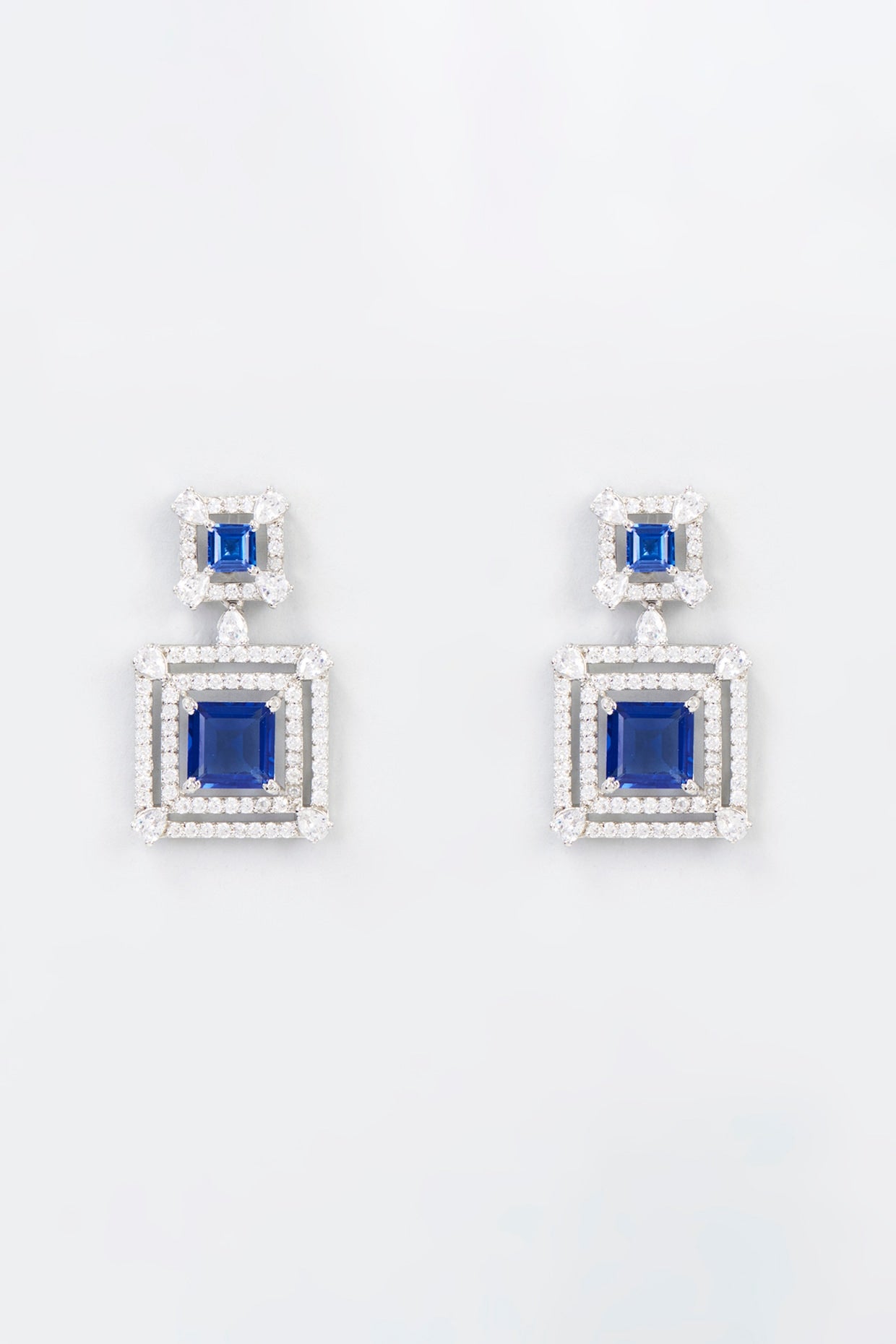 White Finish Zircon & Synthetic Blue Stone Dangler Earrings In Sterling Silver