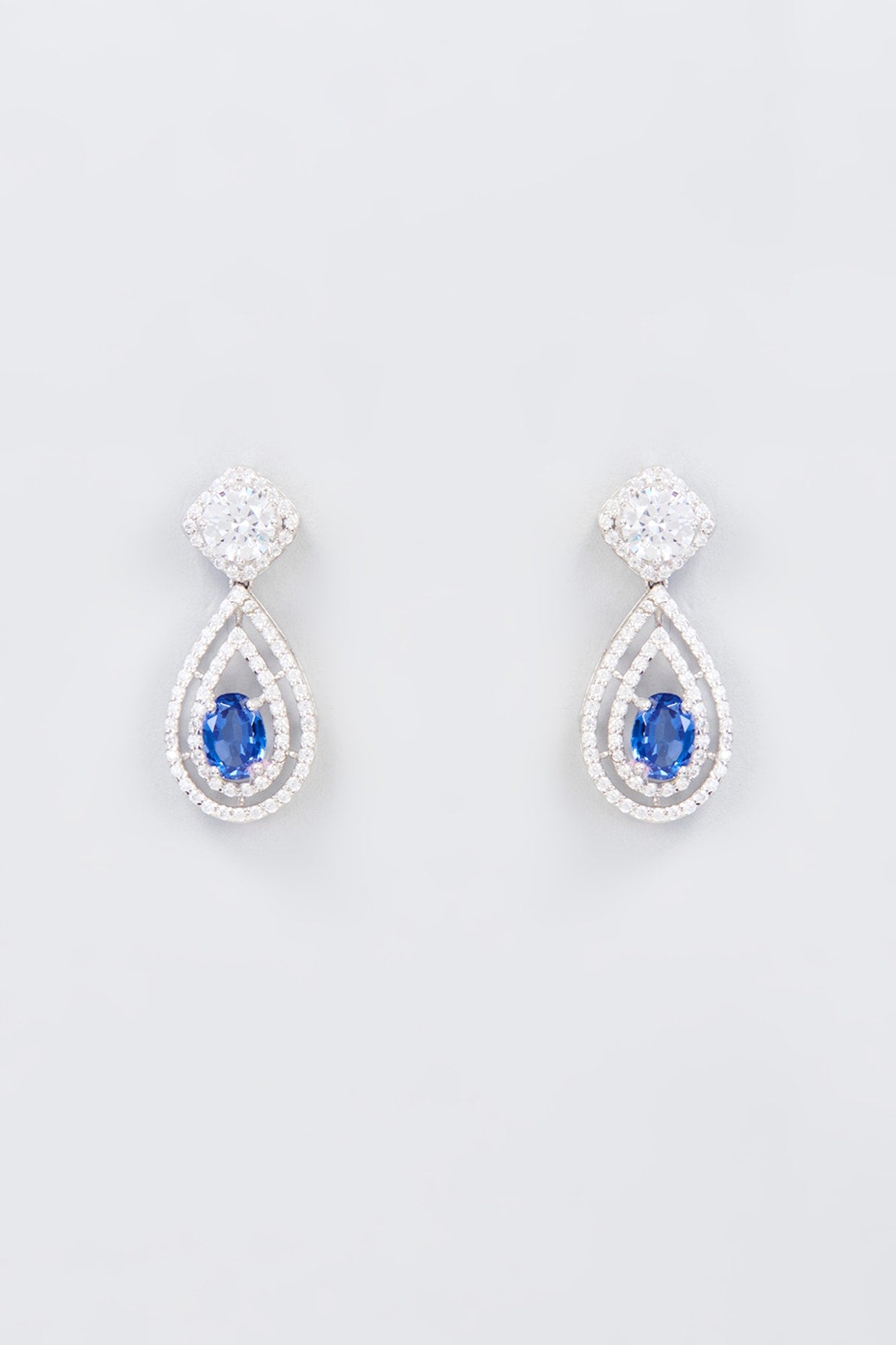 White Finish Zircon & Synthetic Blue Stone Dangler Earrings In Sterling Silver